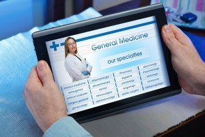 hands of a man looking website of health service in the tablet / man searching web internet for recruitment health insurance on internet with tablet in you home